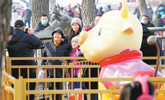 2月12日，颐和园迎来了新春第一批游客，人们举家来到颐和园铜牛处合影，沾“牛气”。今年新添的卡通牛小昂，同样吸引了游客们。北京日报记者 刘平? 摄